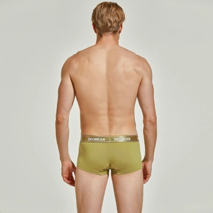 Close-up of olive green knitted boxers with elastic logo waistband on male model