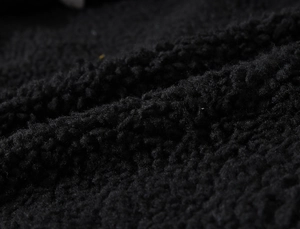 Close-up macro view of thick black faux lamb wool lining texture for winter warmth vest