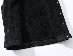 Detail of warm black denim vest with thick sherpa fleece lining and metal buttons