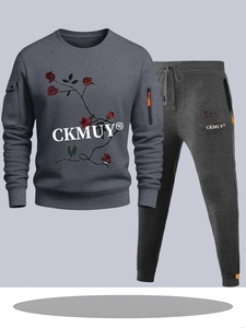 Detail of dark grey track suit featuring red rose graphics and orange zipper accents