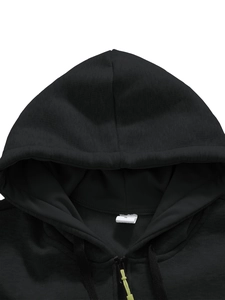 Detail of black hoodie featuring neon green zipper pulls and a size M label inside