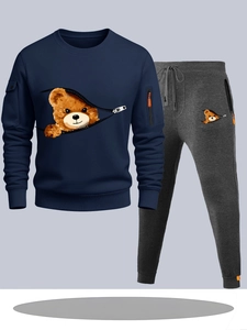 Detail of navy sweatshirt with orange zipper pocket and grey joggers with bear print