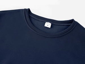 Detail shot of navy blue ribbed crew neck collar with size M label on fleece sweatshirt