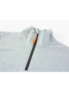 Détail d'un sweat-shirt gris clair avec col montant et fermeture éclair noire à tirette orange