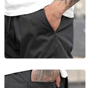 Dettaglio dei pantaloni cargo che mostra la grande tasca laterale e il tessuto liscio