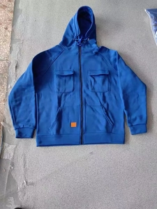 Detail of blue hoodie with tactical flap pockets, drawstring hood and full front zipper