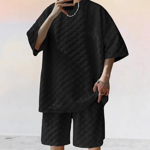 Detail view of men's black two-piece set featuring 3D waffle texture fabric and relaxed fit