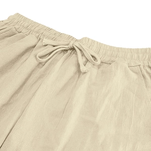 Detailed view of elastic waist and drawstring on men's linen beach trousers in beige
