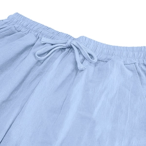 Detail of light blue linen trousers showing elastic waist with drawstring and side pocket