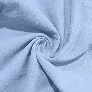 Macro shot of light blue cotton linen fabric showing breathable texture and woven structure