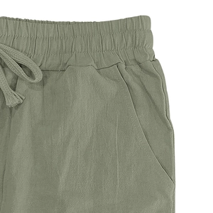 Detail of green cotton linen pants featuring an elastic drawstring waist and side pockets