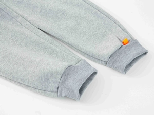 Détail du bas de jogging gris avec ourlet côtelé et étiquette orange sur coton mélangé