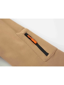 Detail of khaki sweatshirt featuring a black zipper and bright orange silicone puller