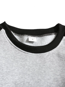 Gros plan du col rond noir côtelé et de la doublure en polaire grise douce du sweatshirt
