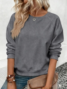 Détail du sweat-shirt gris foncé à col rond avec manches raglan et poignets côtelés porté
