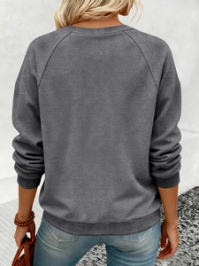 Détail de la manche raglan et des poignets côtelés sur ce sweat-shirt gris foncé