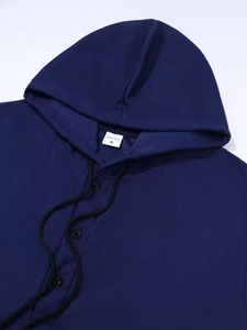 Nahaufnahme des Waffelstrick-Hoodies in Dunkelblau mit Henley-Knopfleiste und Kordelzug