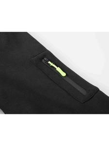 Detail view of high-density black sports hoodie fabric and neon green zipper pocket