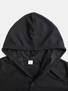 Detailansicht der Waffelstrick-Stoffstruktur und des Größenetiketts auf schwarzem Hoodie
