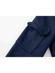 Detail of navy sweatshirt featuring a rectangular flap pocket with black snap buttons