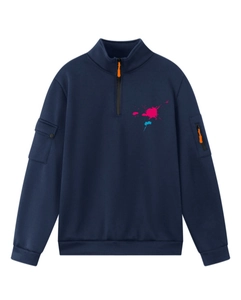Dettaglio felpa blu con mezza zip, schizzi di colore e tasche cargo sulle maniche lunghe