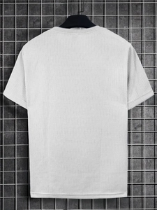Detaillierte Makroansicht der weißen Waffelstrick-Stofftextur eines Herren-Kurzarm-T-Shirts