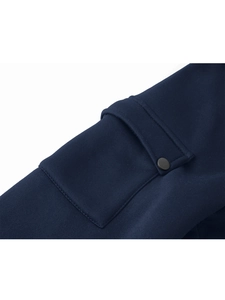 Dettaglio della maglia blu navy con tasca tattica sulla manica e bottone a pressione