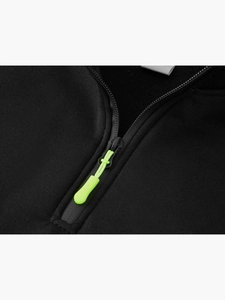 Dettaglio di felpa nera con cerniera e cursore verde fluorescente a contrasto