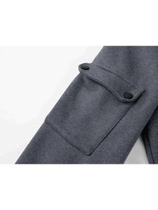 Macro shot of grey melange sweatshirt sleeve detail featuring a pocket with double snap buttons