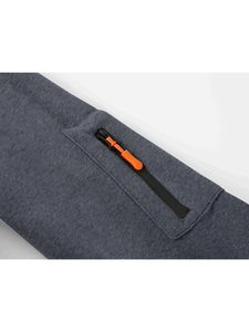 Close-up of a black waterproof zipper with orange puller on dark grey marl sport hoodie