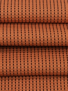 Detailansicht der orangefarbenen Waffelstrickware mit schwarzen vertikalen Streifen