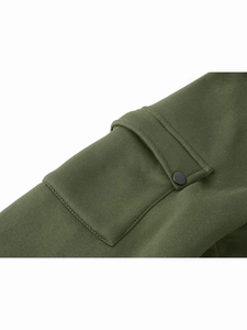Dettaglio della tasca sulla manica verde militare con bottone a pressione in metallo nero