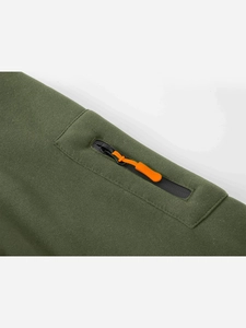 Dettaglio della felpa verde militare con tasca e tirante della zip arancione vivace
