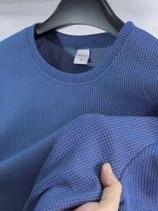 Nahaufnahme der blauen Mesh-Stoffstruktur auf Herren T-Shirt mit Detailansicht des Rundhalses