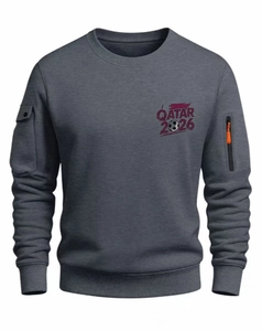 Detail of dark grey sweatshirt featuring zippered sleeve pocket and Qatar 2026 print