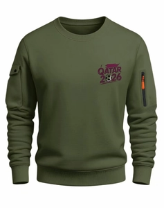 Detail of army green sweatshirt featuring orange zipper pulls and Qatar 2026 sleeve pocket