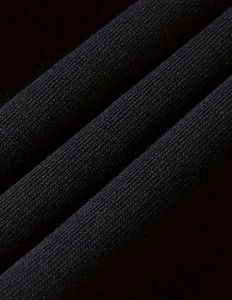 Detailed macro shot of high-quality black ribbed knit fabric with fine texture and soft feel