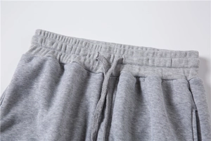 Detail of grey joggers waist featuring elastic waistband and adjustable drawstrings