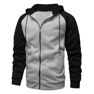 Détail du sweat à capuche zippé bicolore avec corps gris et manches noires contrastées