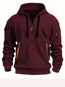 Detail eines burgunderroten taktischen Hoodies mit orangen Reißverschlüssen und Ärmeltaschen