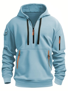 Detail eines hellblauen Hoodies mit Ärmeltaschen und orangefarbenem Reißverschluss