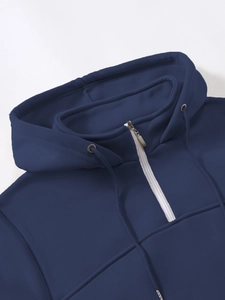 Detail view of the silver half-zip and drawstring on this navy blue hooded sweatshirt