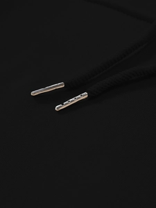 Close-up of black hoodie drawstring with premium silver metallic aglet and woven texture