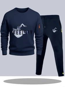Detailweergave van donkerblauw trainingspak met oranje ritszak en bergachtige textuurprint