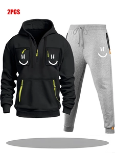 Detail view of men's black half-zip hoodie and grey joggers with smiley pocket designs
