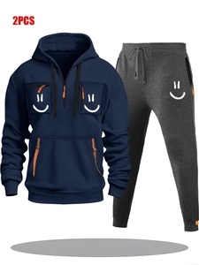 Detail of navy hoodie with smiling face prints on pockets and orange zippers