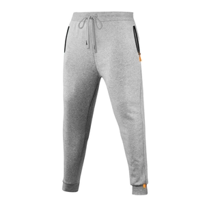 Détail du pantalon de jogging gris avec poches zippées orange et poignets côtelés