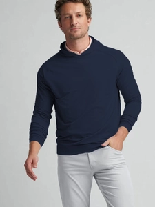 Detail of navy blue hoodie with raglan sleeves over pink polo shirt and grey trousers