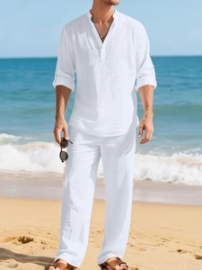 Detail of white linen men's leisure set showing breathable fabric texture on a sunny beach