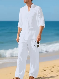 Close-up of white linen blend long-sleeve shirt and trousers on a beach setting